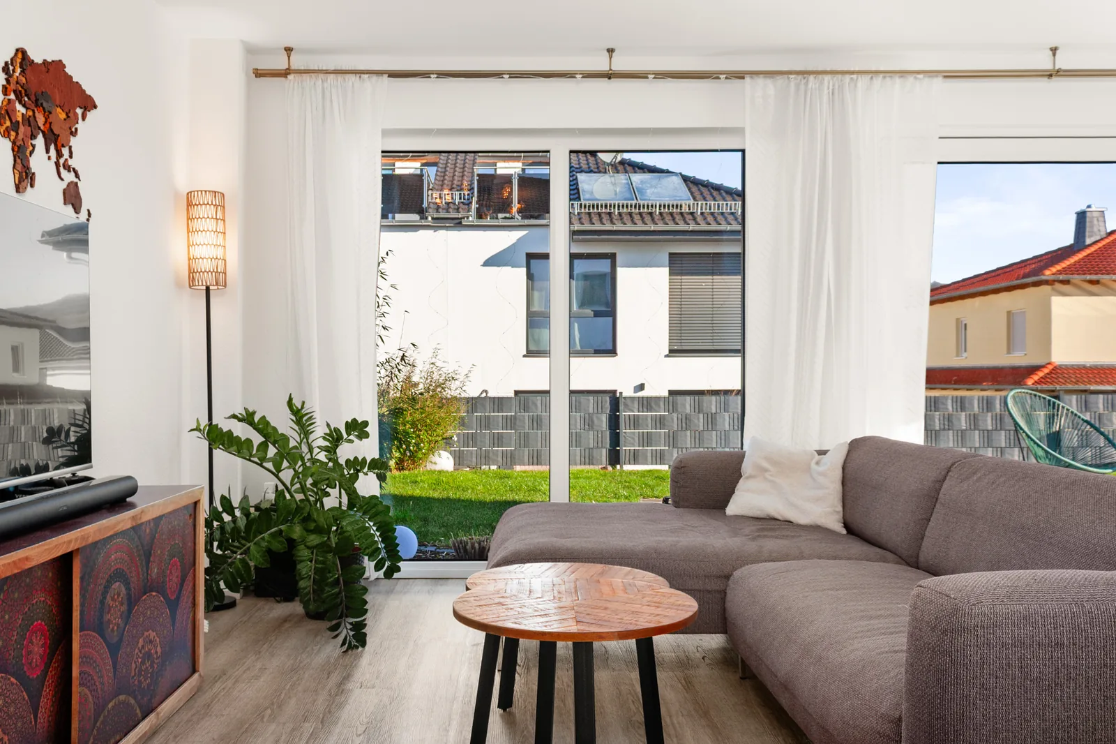 Wohn- und Essbereich mit Flambient-Technik fotografiert: der Raum ist hell und farbtreu, durch die Fensterfront sieht man den Garten.