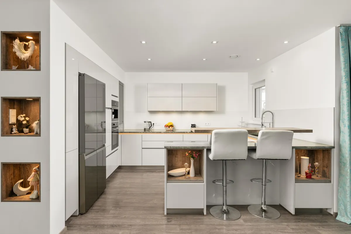 Moderne Küche in Weiß mit Kochinsel und beleuchteten Holznischen