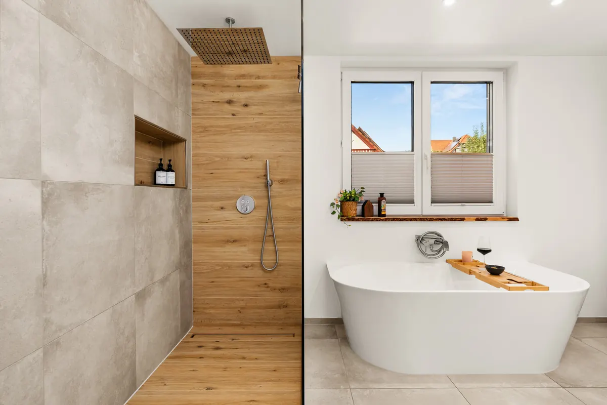 Badezimmer mit freistehender Wanne, Regendusche und Holzwand